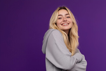 Obraz premium Student in hoodie and sweatpants against purple background with confident smile