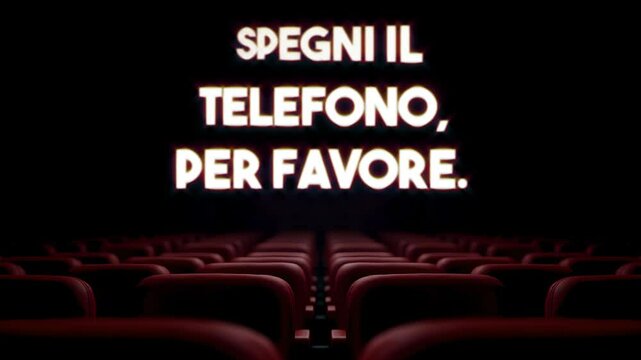 Glowing text SPEGNI IL TELEFONO, PER FAVORE (in Italian: please turn off your phone) appears and dissolves over dark theater interior with rows of empty red velvet seats.
