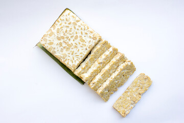 Some slices of raw tempeh on a white background. Tempeh is a nutrient- and protein-rich food with affordable retail prices in traditional markets.