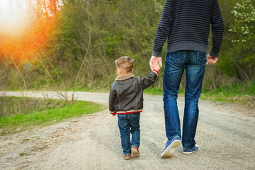 Obraz premium A beautiful hands of parent and child outdoors in the park