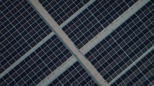 Top down, zoom out view of large solar power panels on the roof. Green technology and renewable energy. Sustainable power resources, using solar cell panels to produce electricty. 