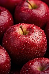 Freshly harvested red apples with water droplets glistening under soft light