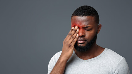 African guy rubs his eye, suffering from conjunctivitis, ocular diseases concept
