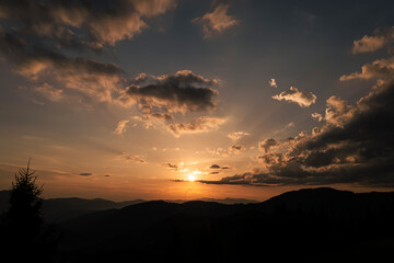 Orange sunset with the setting sun behind the mountains