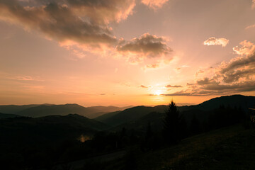 Obraz premium Orange sunset with the setting sun behind the mountains
