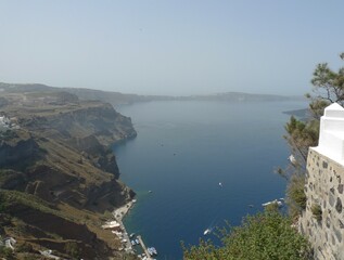 Fototapeta premium Partial view of the impressive cliff of Fira as it rises above the old port overlooking the sunken caldera and the Aegean Sea