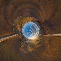 Obraz premium blue hole sphere or globe little planet inside sand or dry ground frame background with tractor tracks