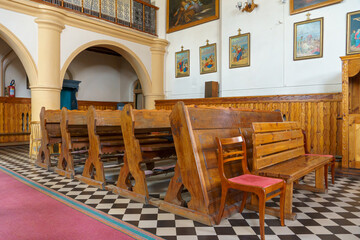 Benches in the Catholic church. The interior of the church. Places for temple visitors to pray.