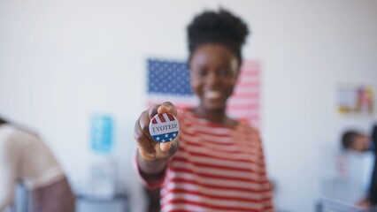 African American woman in blurred vision shoving to camera round pin saying 