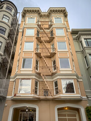 Yellow facade of a building in San Francisco, California, USA with typical american fire escape...