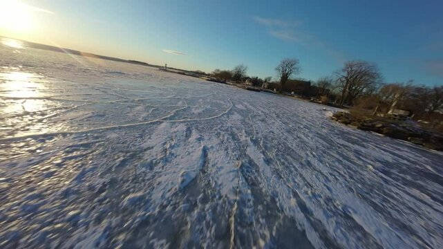 FPV Flight Over Frozen River During Sunset In Lachine, Quebec, Canada. - aerial shot