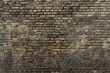 Obraz premium Seamless textured wall made of aged, weathered bricks in various shades of gray and brown. The surface shows signs of wear.