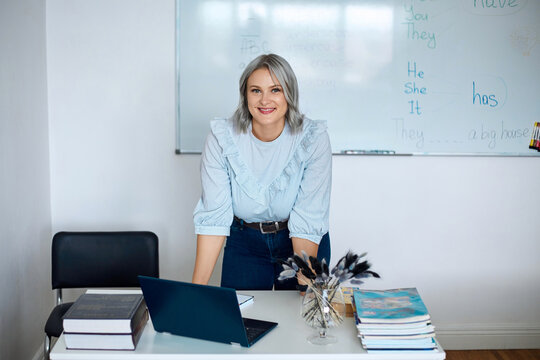 Portrait of an English teacher in a classroom against a white board background