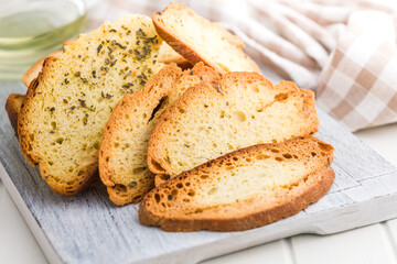 Crispy roasted bruschetta bread on cutting board.