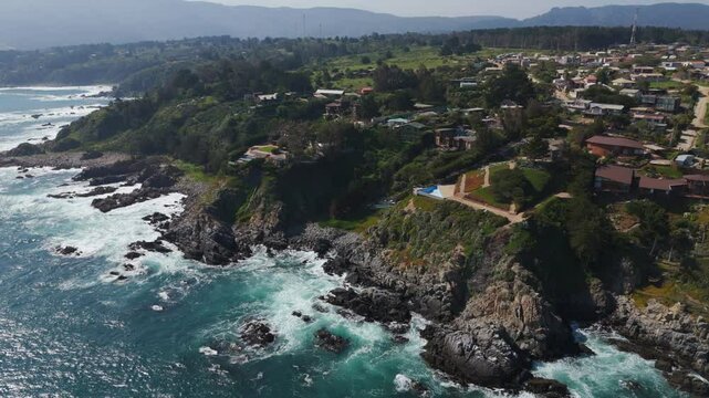 Aerial view of charming cliff top homes overlooking the Pacific Ocean in Caleta Quintay, Casablanca, Valpara&iacute;so, Chile.Dolly Left Shot