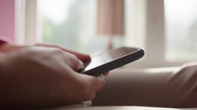 Mindless scrolling on smartphone, lots of screen time in tech age. Hand closeup
