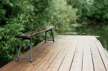 Vintage film image of wooden pier deck with beautiful lake scenery on rainy day in forest, copy space