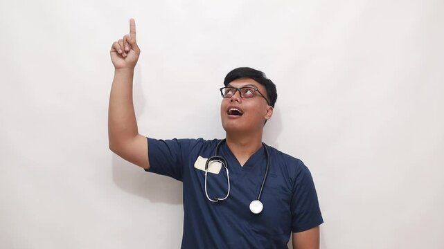 Asian male doctor pointing above using his hand to direct attention. Isolated on white background
