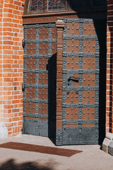 Wooden door with decorative ornaments - entrance to the Gothic Cathedral 