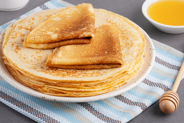 Stack of traditional russian pancakes blini on gray background. Homemade russian thin pancakes...
