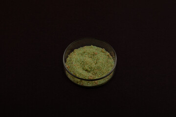 Iron(II) sulfate powder or ferrous sulfate in Petri dish. Green vitriol, Iron vitriol. Fertilizer. Soil amendment for lowering pH of high alkaline soil so that plants can access soil's nutrients