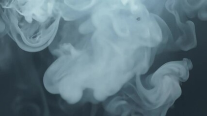 The soft, swirling gray smoke drifts gently through a dark background, creating a mysterious and calming atmosphere that captivates attention