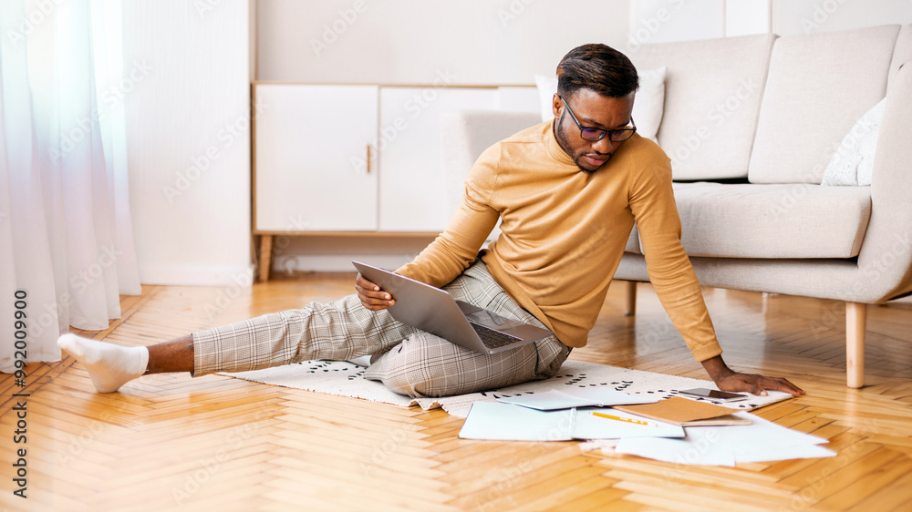 Poster African American Student Using Laptop Studying Or Working On Project Sitting On Floor At Home. Selective Focus