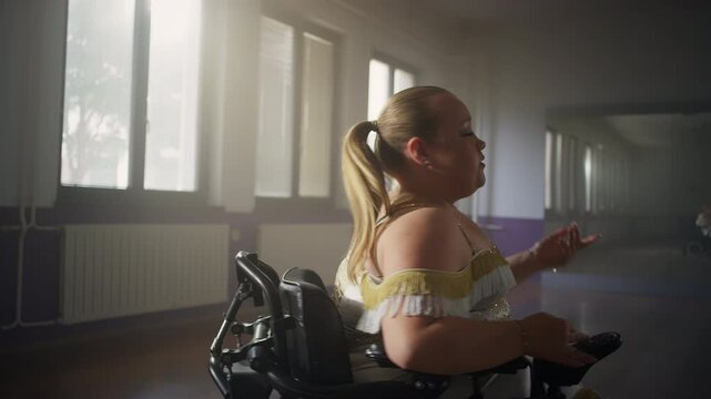Smiling young woman with a disability, a wheelchair dancer enjoying performing graceful dance moves, medium close up shot. Sport and wellbeing concept.