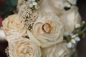 Romantic Elegant Wedding Rings Nestled Among Beautiful Cream Roses