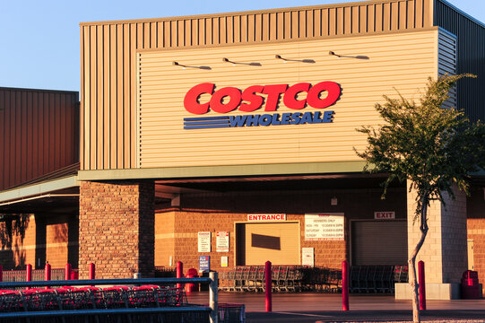 An early morning exterior view of a Costco Wholesale store in Mesa, Arizona, highlighting the brand name, logo, and shopping carts