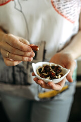 A casual moment of snacking on mixed nuts in a cozy kitchen setting during a sunny afternoon