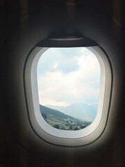 Fototapeta premium Airplane taking off or landing, view on mountains from window
