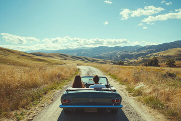 A couple taking scenic drive on sunny Sunday, enjoying beautiful landscape and open road. vibrant hills and clear sky create perfect backdrop for their adventure