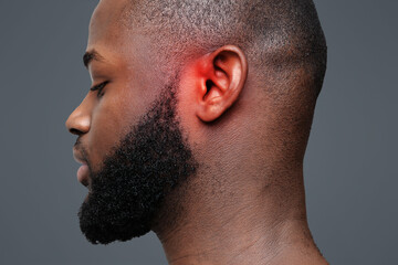 Side view of afro man with inflamed ear, close up