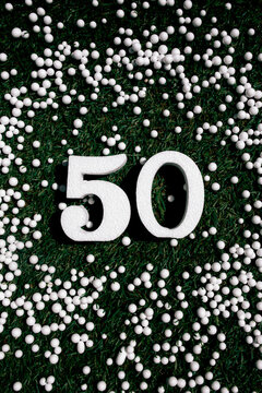 White number 50 on a grassy background with polystyrene balls