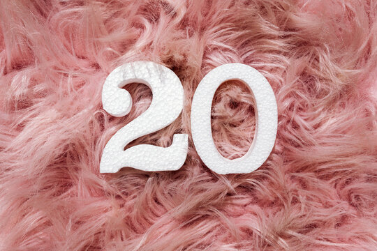 White number 20 on a fluffy pink feather background