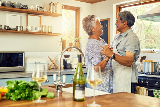 Dance, love and senior couple in kitchen for bonding, loving relationship and romance together in home. Retirement, marriage and mature man and woman with wine for cooking meal, lunch and dinner