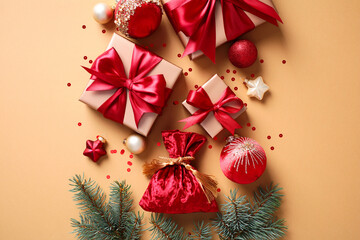 Santa bag and gift boxes with red ribbons, baubles, and pine branches on a warm beige background
