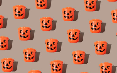 The plastic orange bucket on a gray pastel background, Halloween concept. Trick-or-treat idea. Holiday pattern idea.