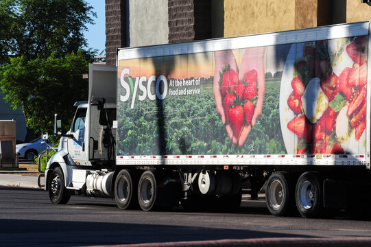 A Sysco Wholesale Restaurant Food Distributor semi-truck making a delivery at a strip mall in Mesa, Arizona