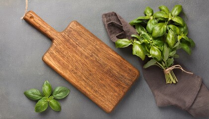 Basil on a cutting board on a grey kitchen table.