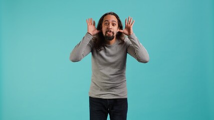 Portrait of spiteful man making exaggerated silly faces, mimicking someone, doing mocking...