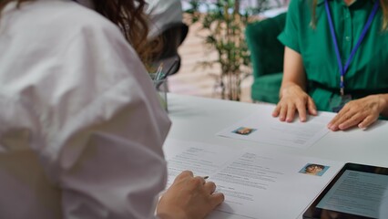 HR staff going through the selection process phase of the recruitment activity, choosing the best...