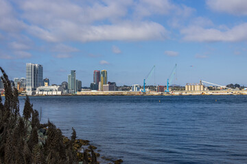skyscrapers, office buildings, the San Diego Convention Center and cranes along the coast of the San Diego Bay at Coronado Tidelands Park in Coronado California USA