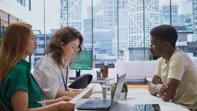 HR manager conducting a detailed interview with a potential candidate in a modern office, discussing qualifications, previous experience and career goals. Headhunter studies CV. Camera B.