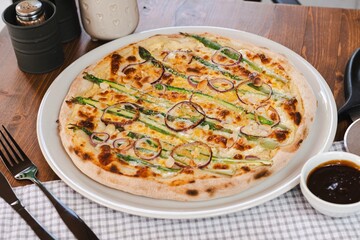 pizza with asparagus onions and almonds on the background of the restaurant