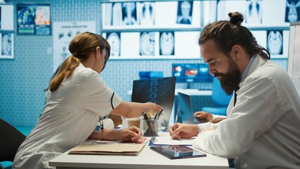 Medical professionals analyzing anatomy x ray scans to find the best treatment, research meeting....