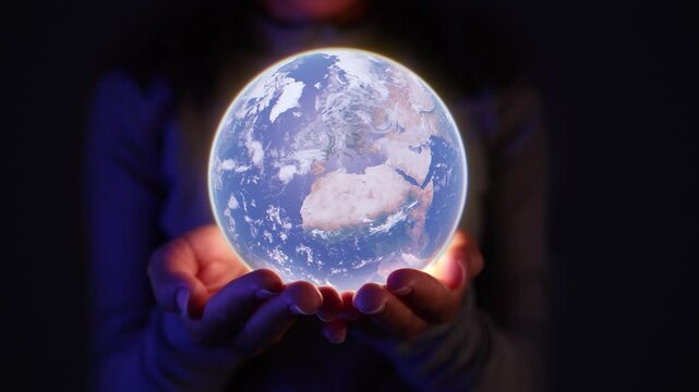 Woman hands holding a glowing globe, symbolizing global unity and hope