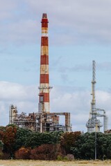 Fototapeta premium Oil refinery chimney at the decommisioned Marsden Point Refinery, Whangarei, Northland, New Zealand.