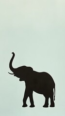Obraz premium A serene elephant silhouette standing tall, with its trunk raised, set against a pale green background